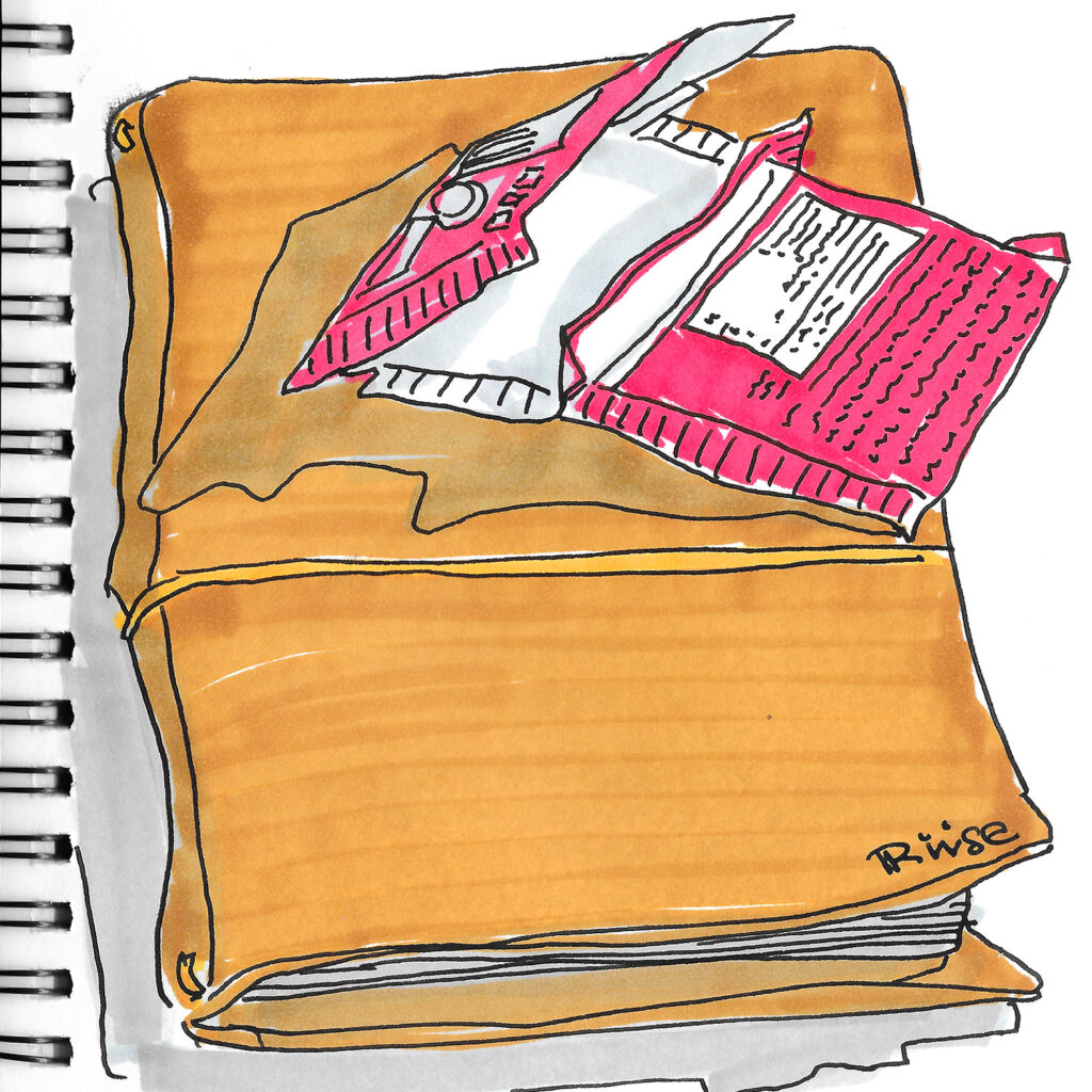 Sketch of a leather sketchbook bound with Riise printed in the corner and an empty chocolate bar wrapping on top