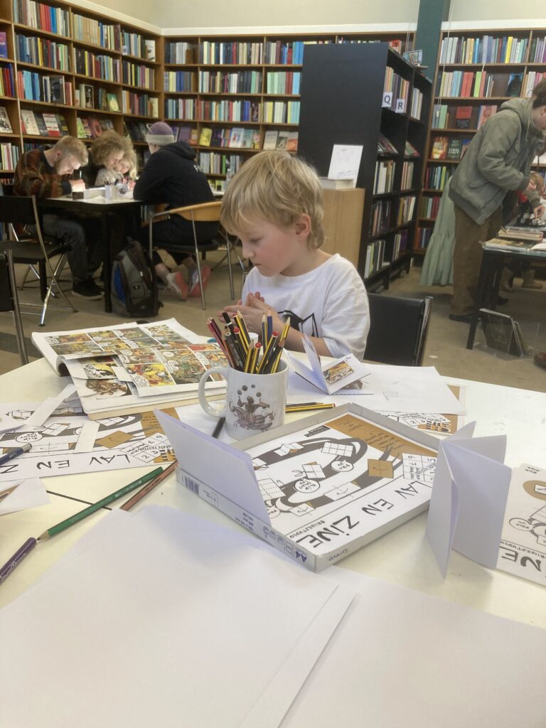 workshop tables with people making zines